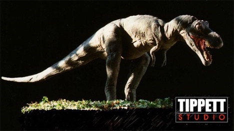 A T-Rex dinosaur model illuminated from the top. The logo of Tippett Studio marks this image in the bottom right.