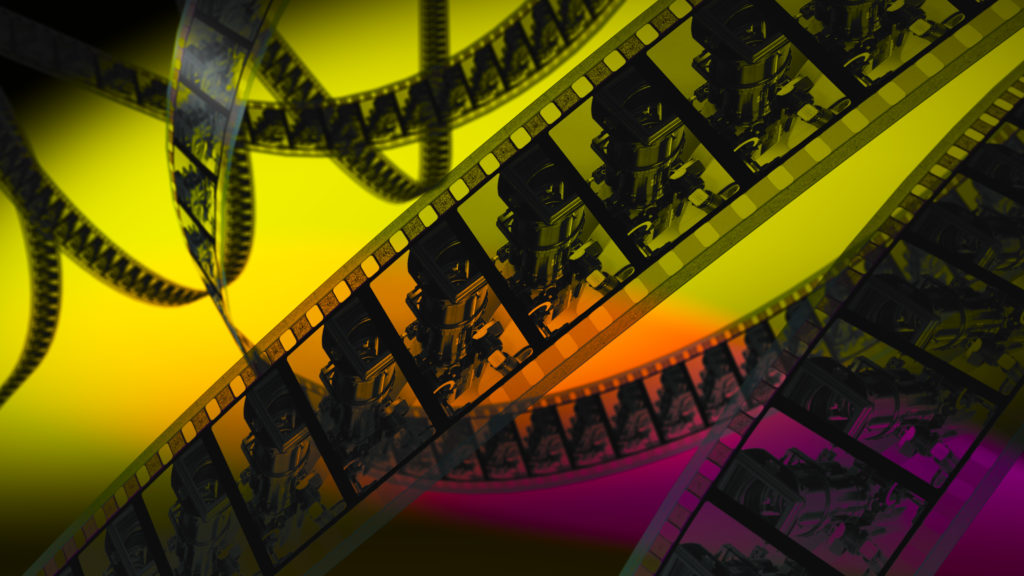 Unspooled celluloid on yellow, orange, and purple background. 