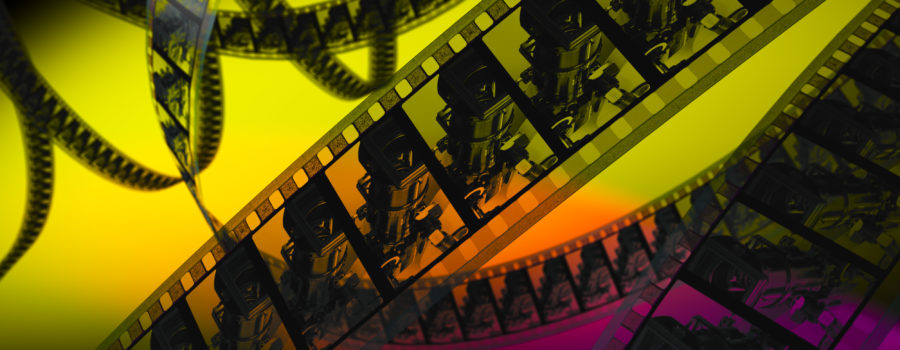 Unspooled celluloid on yellow, orange, and purple background.