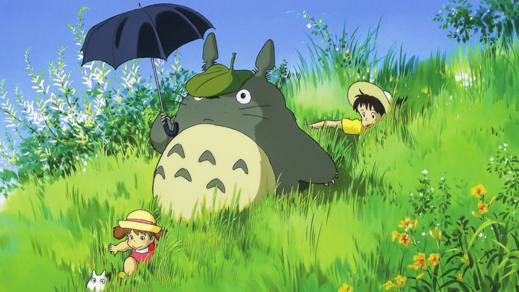 An animated image of two girls sliding down a grassy hill, with a large, round, gray-colored creature holding an umbrella and wearing a leaf as a hat.