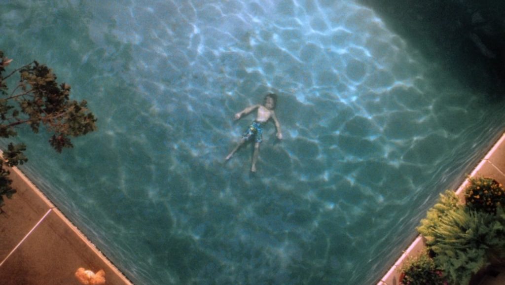 Android David (Haley Joel Osment) shown laying underwater in his family's swimming pool from a bird’s eye view. 