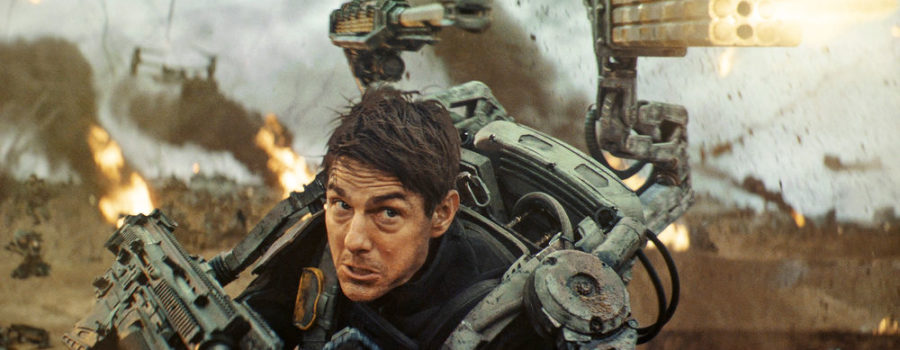 Tom Cruise wearing full armor and firing multiple guns in the film Edge of Tomorrow.