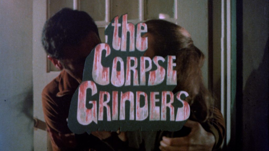 The title "The Corpse Grinders" appears over an image of a man and woman embracing.