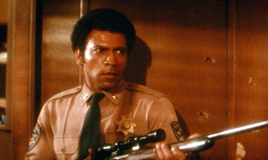 Image of Lt. Bishop (Austin Stoker) wearing a uniform and holding a rifle in "Assault on Precinct 13."