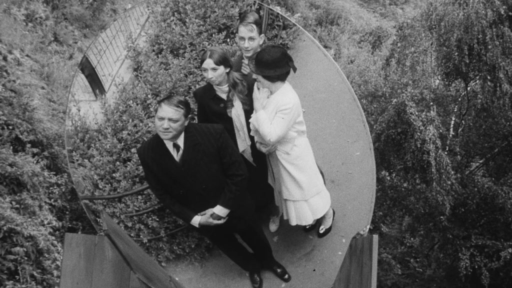 A man, Karel, and his family are seen in a convex mirror.