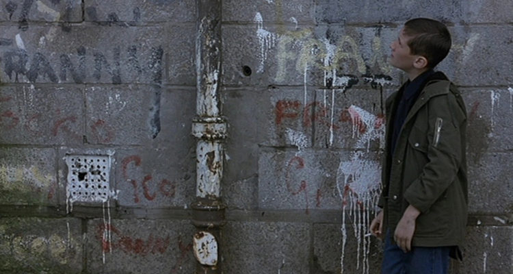 James looks at a graffiti filled wall in his neighborhood.