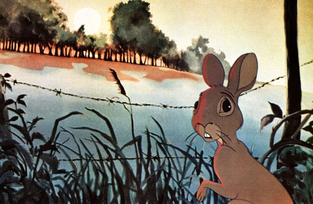 Animated image of a rabbit looking over his shoulder, a barbed-wire fence and a forest visible in the background.