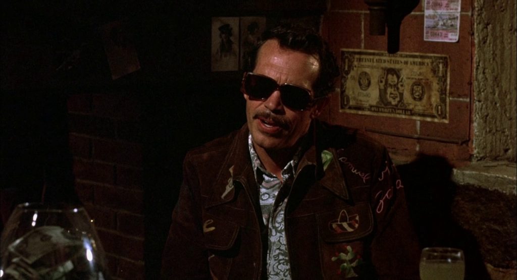 Bennie, a white male in dark sunglasses and brown jacket, is seen in a bar.