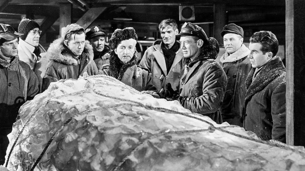 Captain Hendry and his airmen examine The Thing encased in ice.