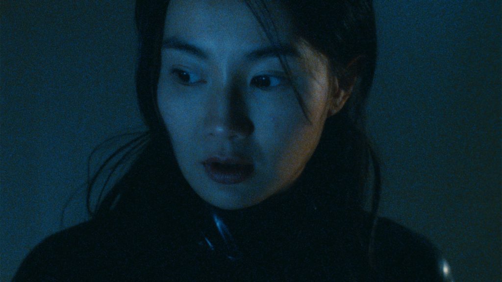 A dark, blue-tinged close-up of Maggie Cheung in "Irma Vep."