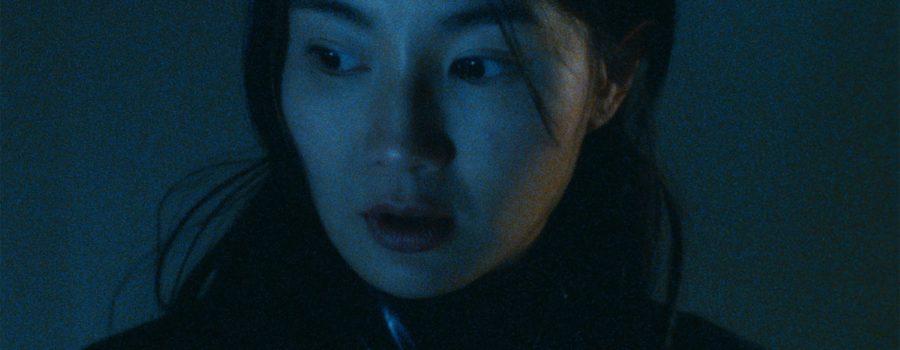 A dark, blue-tinged close-up of Maggie Cheung in "Irma Vep."