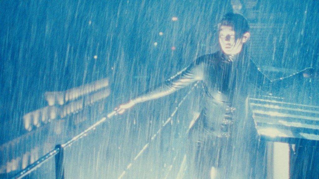 Maggie Cheung donning the Irma Vep catsuit and sneaking around on a rooftop as the rain pours.