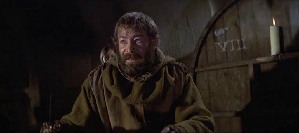 King Henry (Peter O'Toole) stands in a dark room to defend himself against his sons. Just over the left side of his head stands a woman. To the right is a wooden wall marked with a VIII.