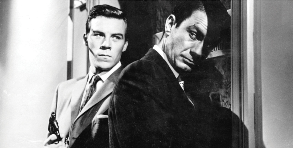 Gus (Richard Rust, left) holds a gun as Tolly (Cliff Robertson, right) opens a door