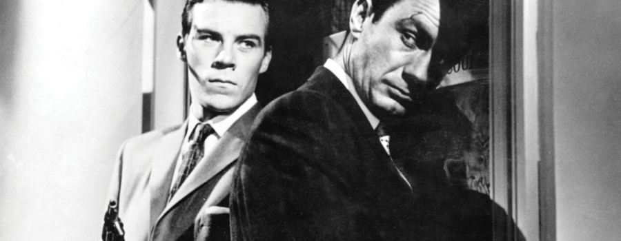 Gus (Richard Rust, left) holds a gun as Tolly (Cliff Robertson, right) opens a door