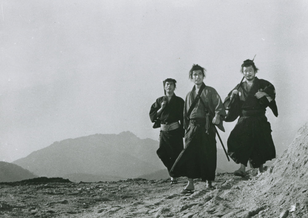 The Three Outlaw Samurai standing in a barren landscape, look into the distance.