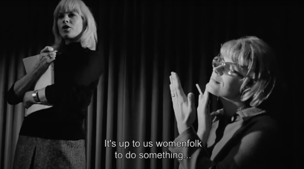 A woman on the left stands upright with a script pressed to her chest. Another woman stands to her right, holding a cigarette. Below them is text that reads, "It's up to us womenfolk to do something". 