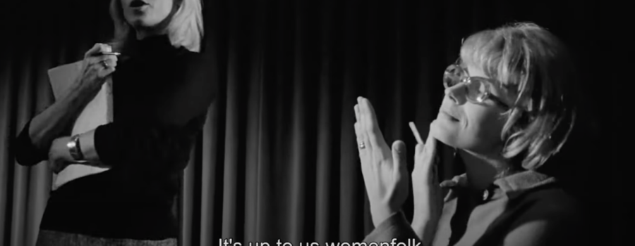 A woman on the left stands upright with a script pressed to her chest. Another woman stands to her right, holding a cigarette. Below them is text that reads, "It's up to us womenfolk to do something".