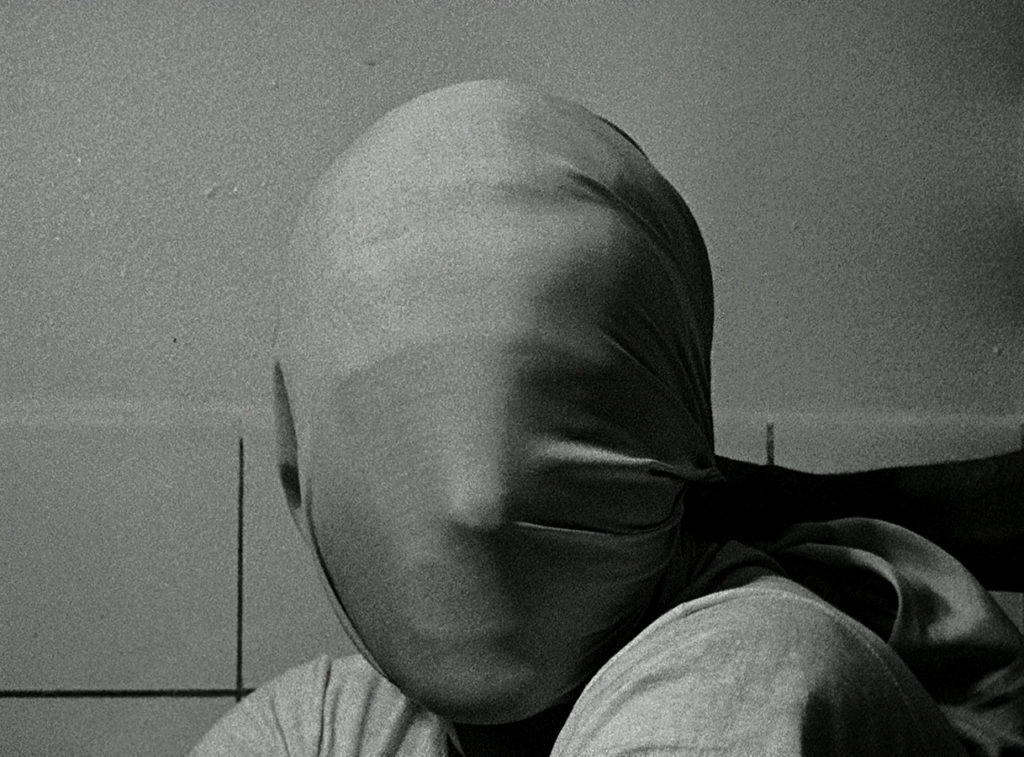 A close-up of a human figure with a cloth pulled tightly across their face, from the film Le Petit Soldat.