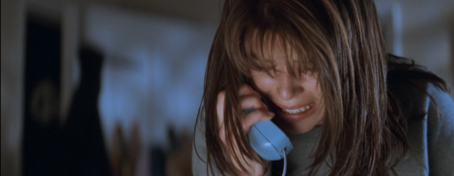 Sidney Prescott clutches a baby blue phone to her ear in terror