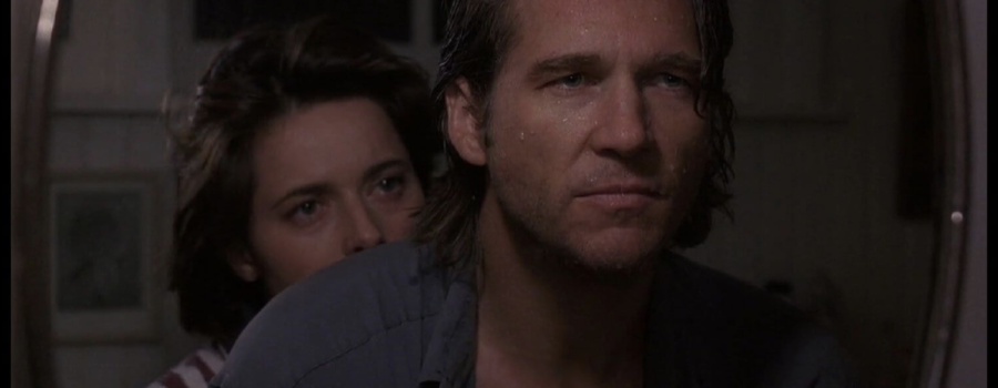 A hot Jeff Bridges glistens with sweat as he stares out a window. Isabella Rossellini pokes her head out from behind his shoulder.