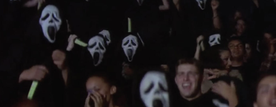a room filled with people in Ghostface masks holding glow-in-the-dark knives in the air, poised to kill.