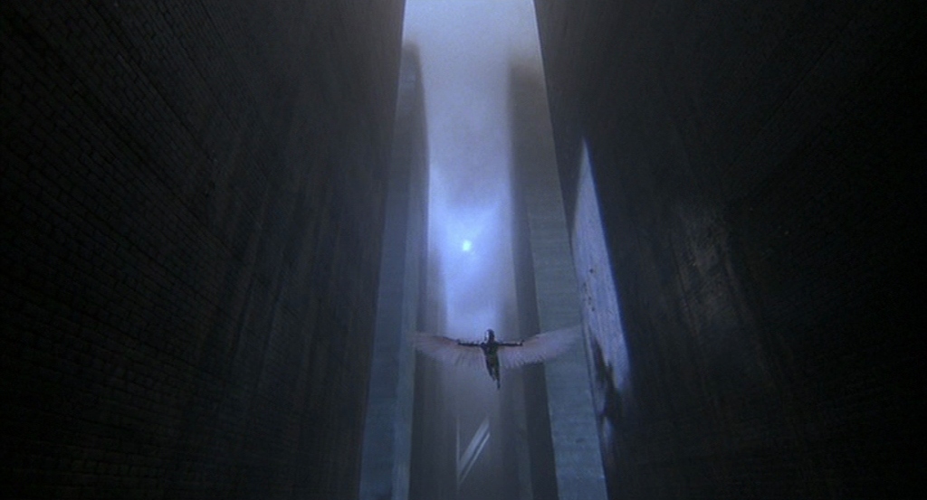 Sam Lowry (Jonathan Pryce) soars through a dark cityscape in a winged suit of armor.