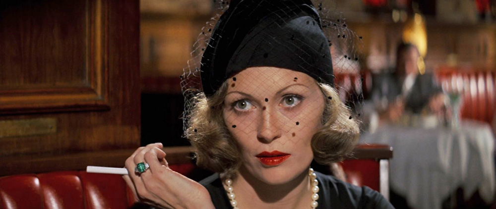 Faye Dunaway in character as Evelyn Mulwray in Chinatown. The image is a close-up of the character at a restaurant.