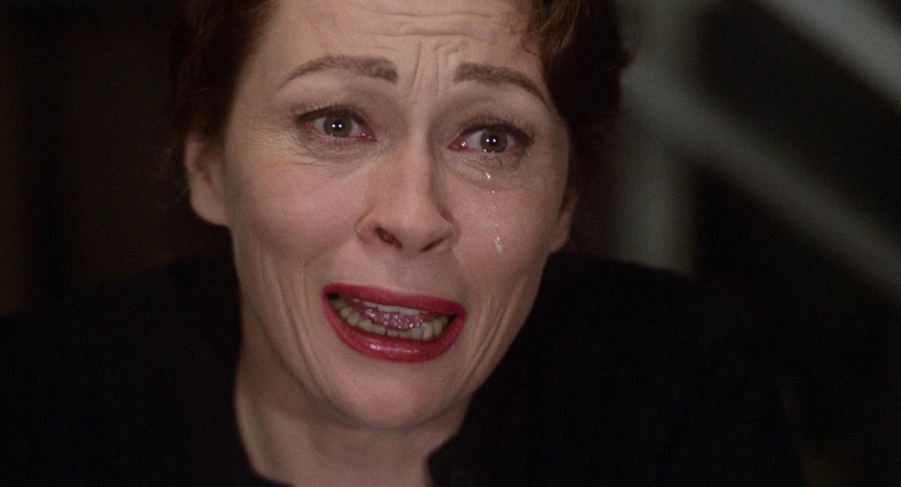 Faye Dunaway in character as Joan Crawford in Mommie Dearest. The image is a close-up and she is crying.