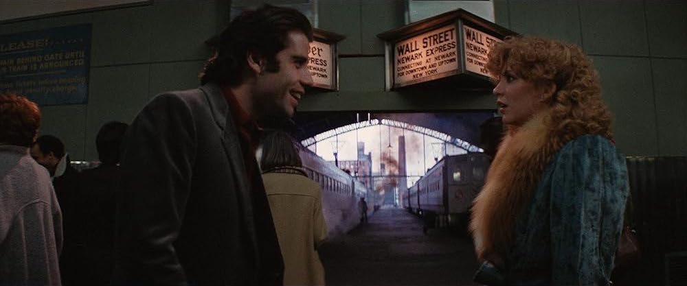 Jack, a young light-skinned man with dark hair, and Sally, a young woman with blonde curly hair, are standing on a train starting platform facing each other, with side characters and trains in the background.