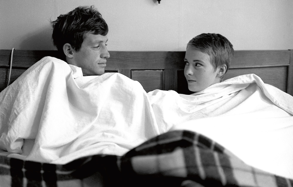 Michel Poiccard and Patricia Franchini Under a sheet, sitting in bed talking.