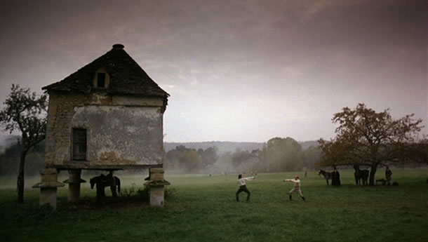 Harvey Keitel as Gabriel Feraud duels a man with a sword in a foggy field.