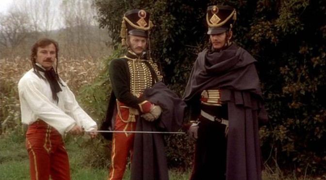 Harvey Keitel as Feraud stands next to two comrades, with a drawn sword.]