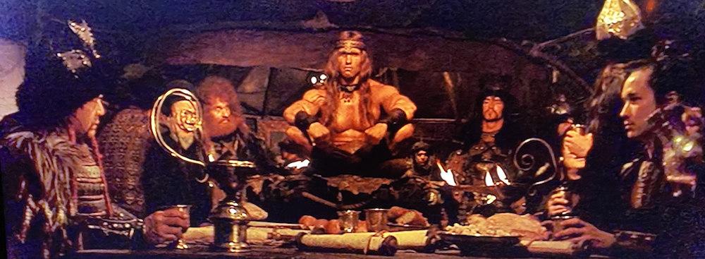 Conan sits cross-legged in a yurt surrounded by warlords of Khitai. 