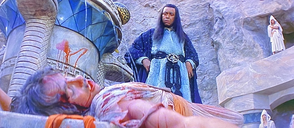 Thulsa Doom approaches a beaten and bloodied Conan.