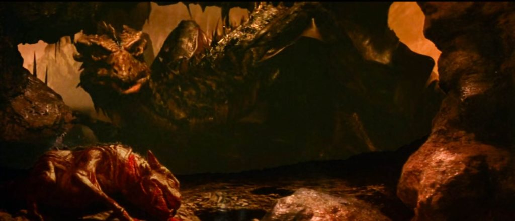 Wide shot of a large dragon, Vermithax Pejorative, in a cave. There is the bloody corpse of a dragon baby in the foreground.