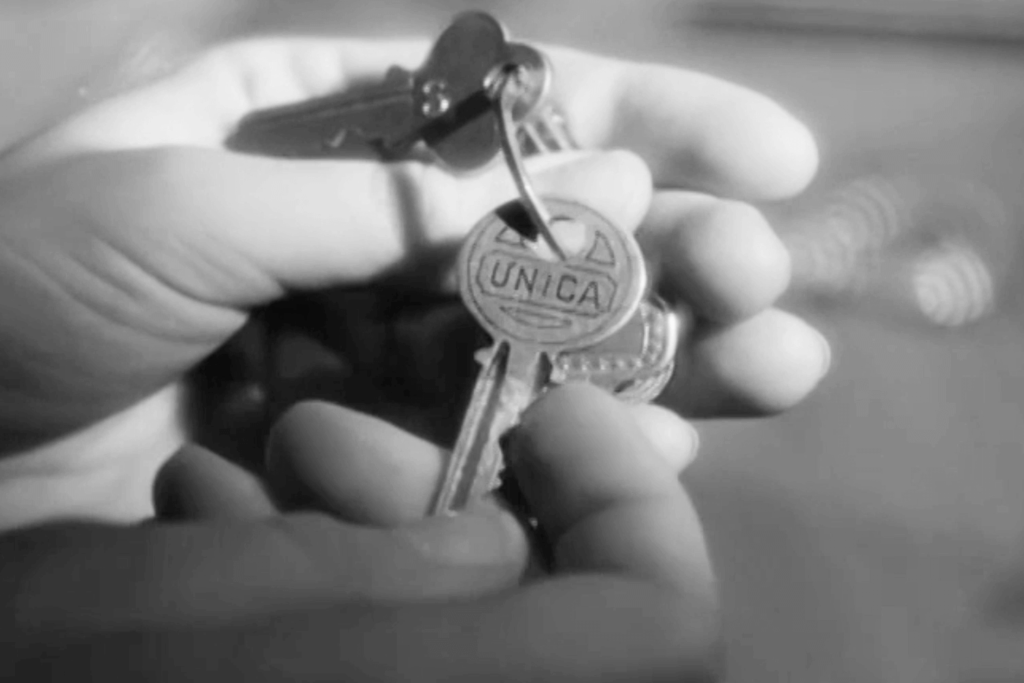 Hands holding a ring of keys, with “UNICA” written across the one in focus.