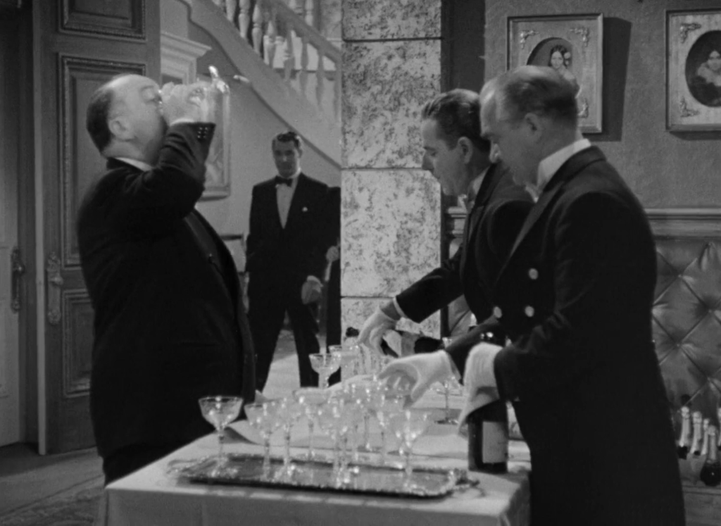 Alfred Hitchcock downs a glass of champagne in his Notorious cameo. “Here’s to the props department!”