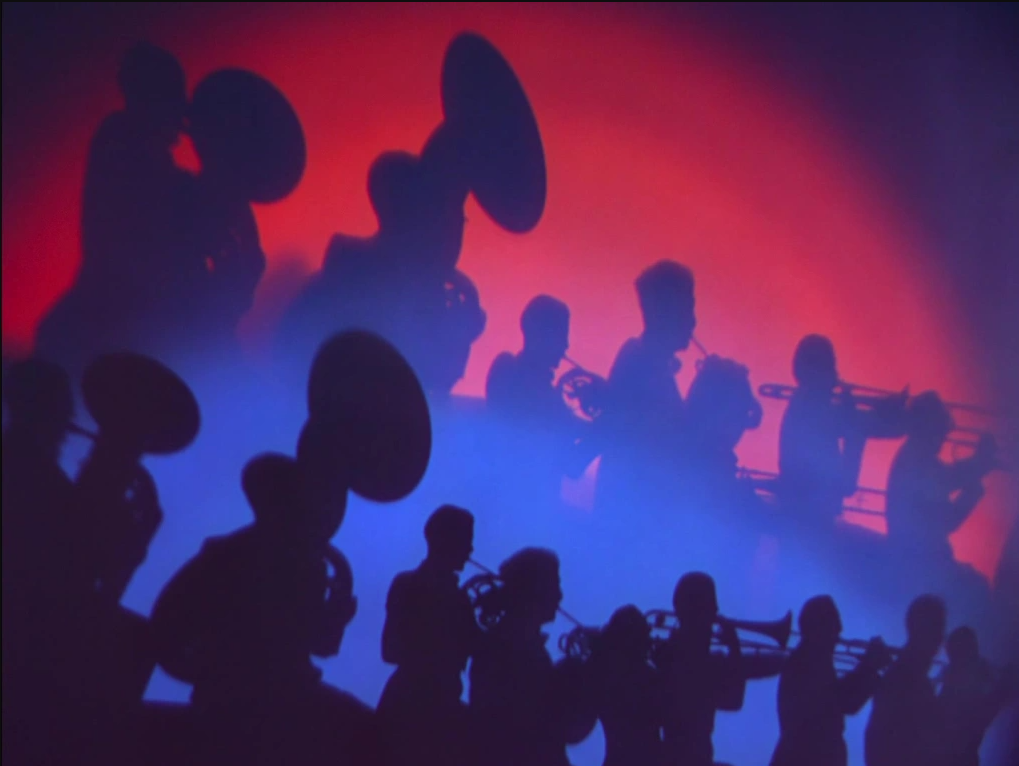 Silhouettes of an orchestra silhouette with shadows looming in blue against a red background