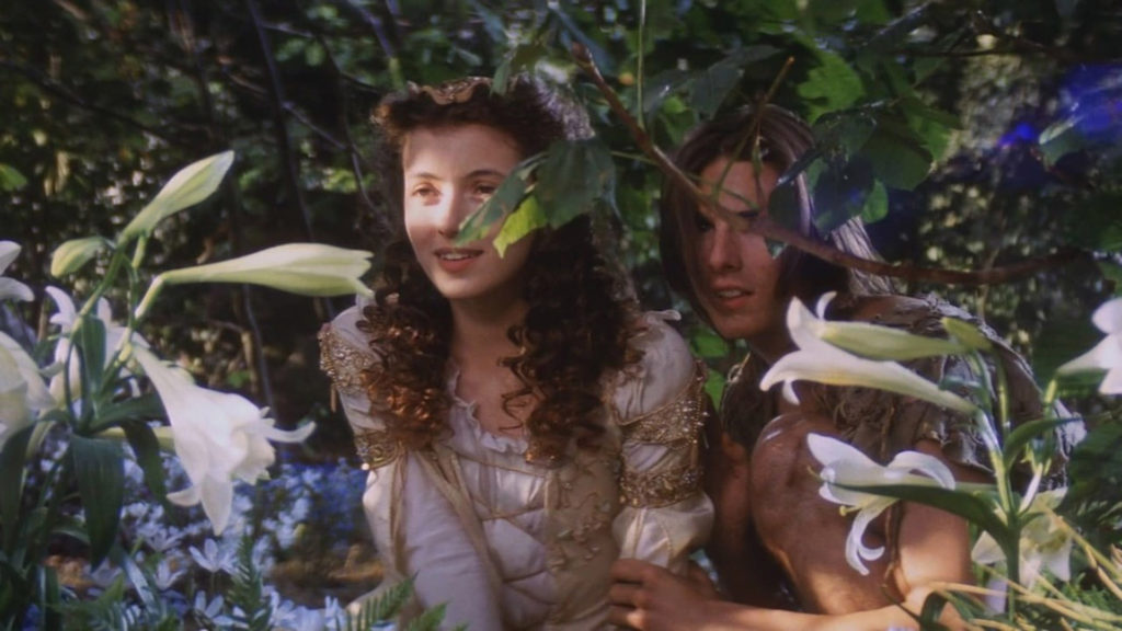 A young princess in a white and gold dress sits in the woods, with a young man seated to her right. His face is obscured by leaves. White lilies frame the pair from the bottom corners of the image.