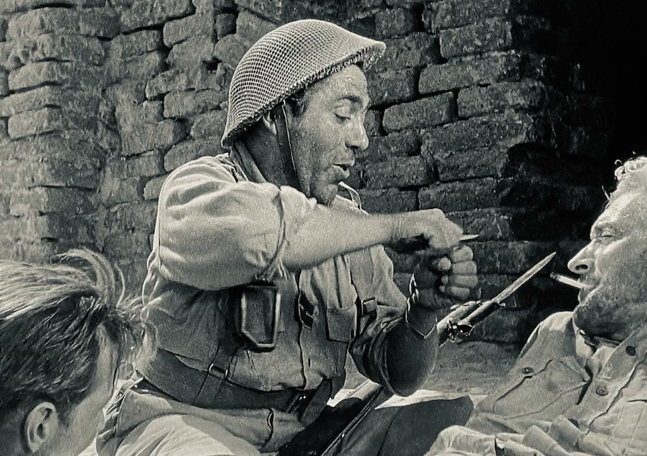 Infantryman Frenchie entertains troops with a story of how to eat cheese in his village.