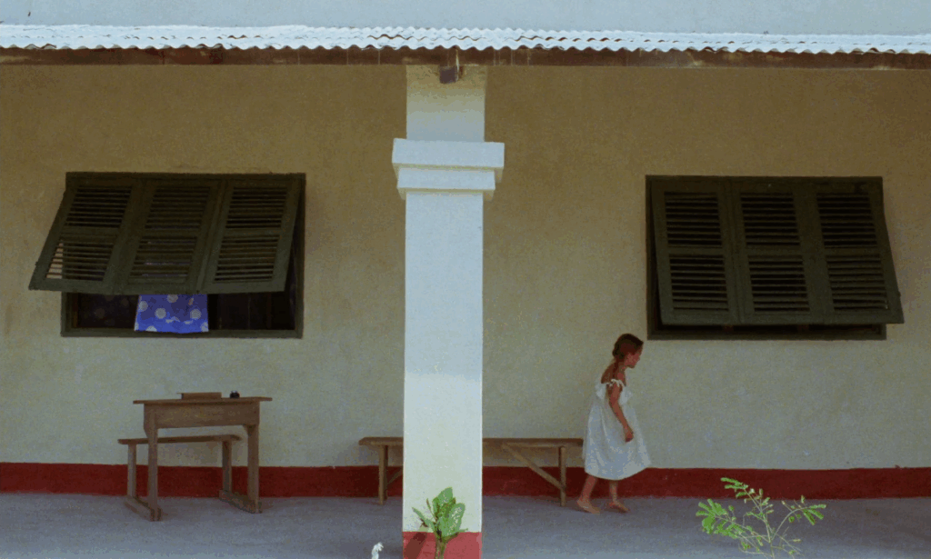 A young child walks alongside the colorful wall of a building