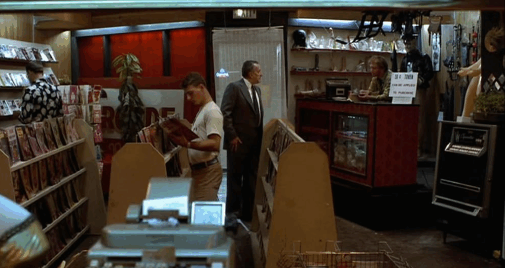 Jake stands in a video store.