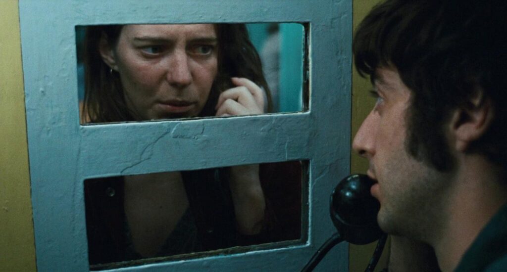A woman visits a man in jail.
