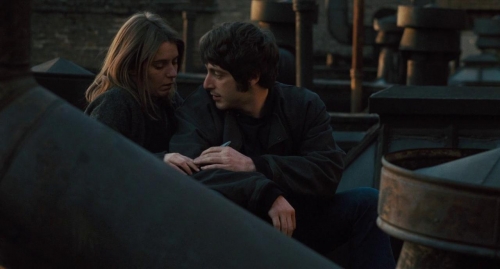 A man and a woman sit on a bench.
