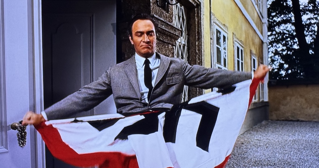 Baron von Trapp tears a Nazi flag in half.