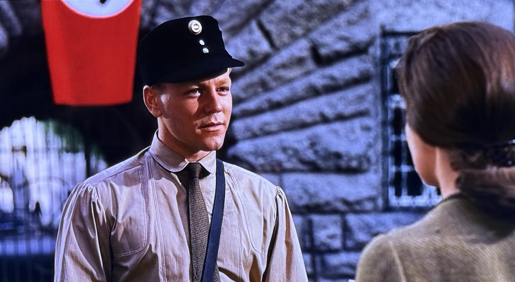 Rolf, the mail-boy-turned-nazi talks with Lisel in front of a Nazi flag.