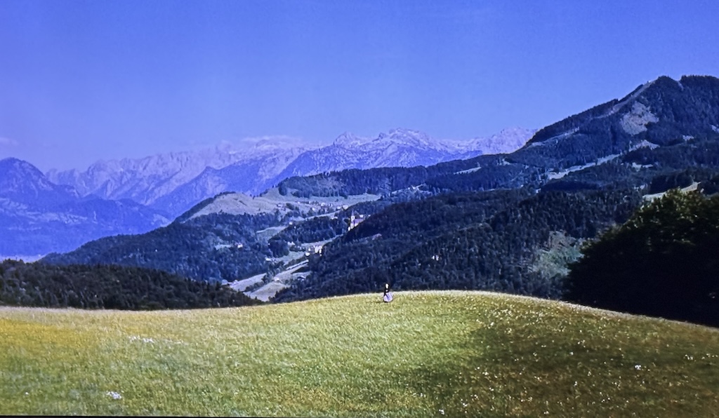 Wide shot of the Austrian Alps, with Sister Maria singing in a field, from the opening of the Sound of Music.
