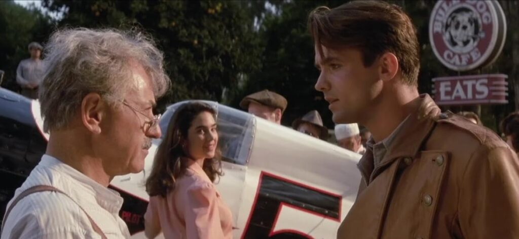 A woman looks on admiringly as the two men involved with the jetpack talk to each other