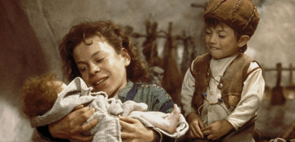 willow (left) holds a baby in his hands. there is a small human standing to his right.